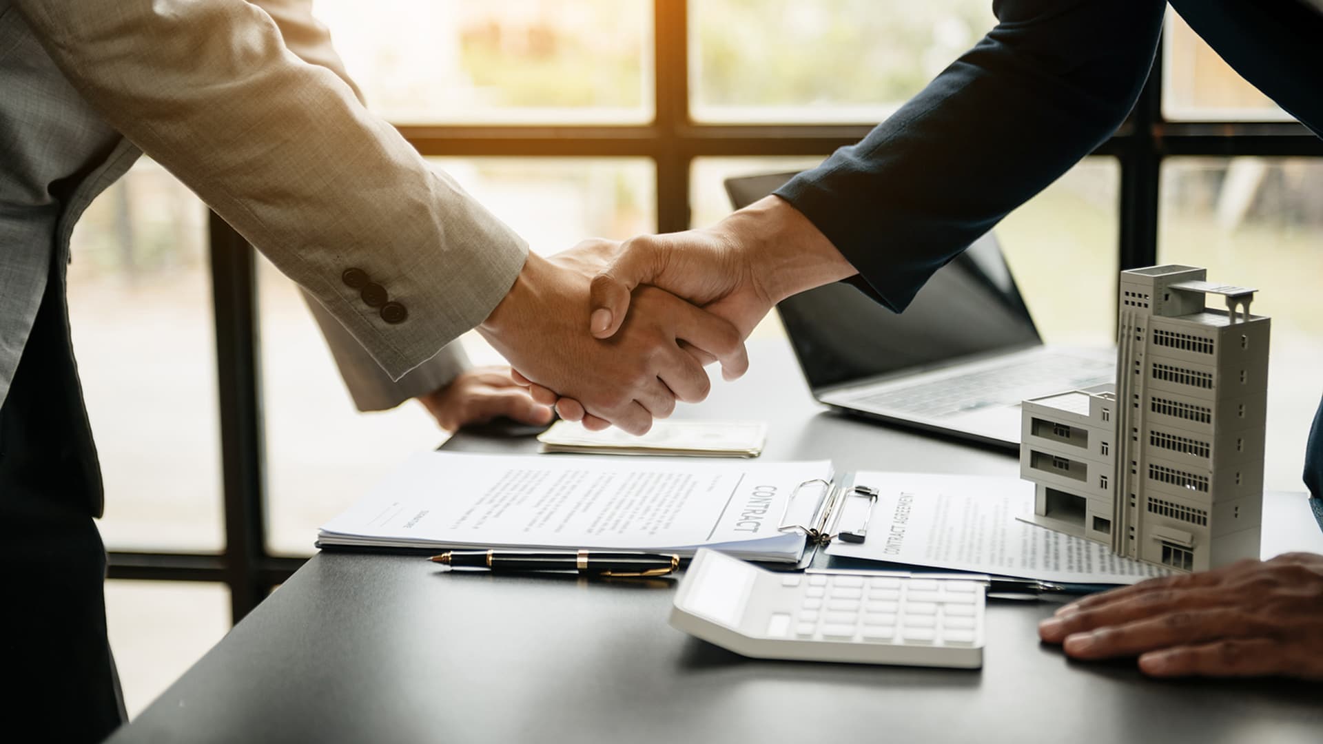 Go-GP depicted by a handshake deal over commercial financing paperwork